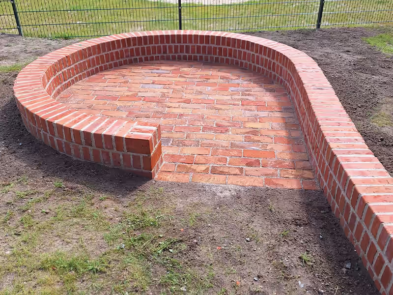 Runde Klinker-Sitzbank mit gepflasterter Fläche in einer Gartenanlage in Görlitz nahe Dresden